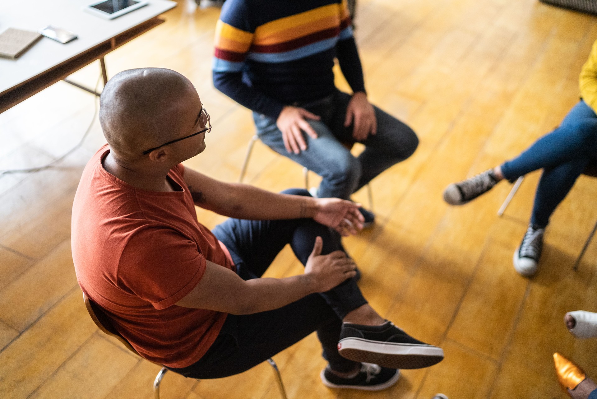 Young man talking in group therapy at a coworking