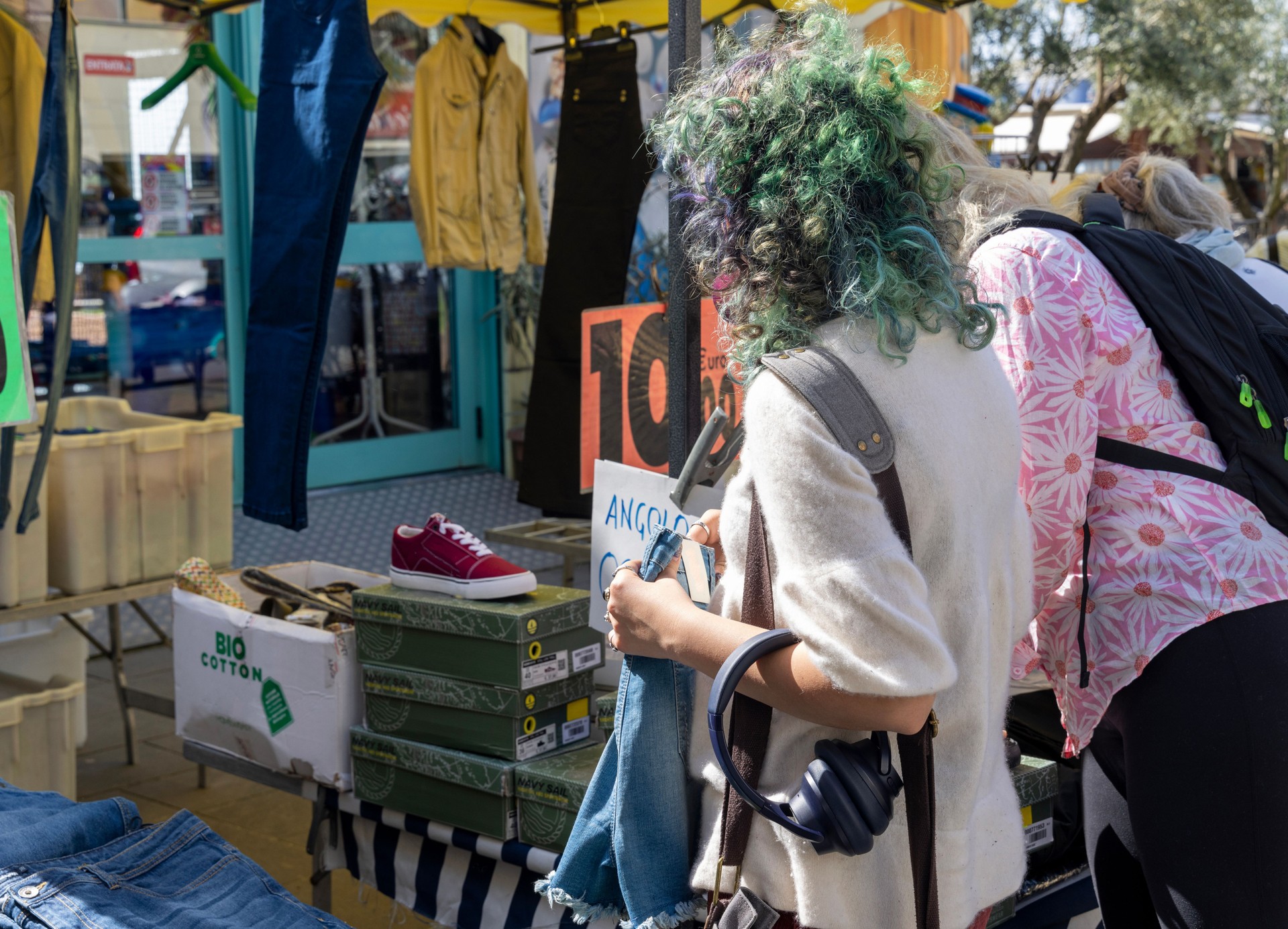 Young, generation z, woman shops for clothing at outdoor market